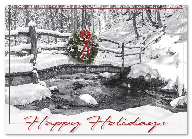 A snow-laden woodland bridge, graced with a holiday wreath lends its peaceful beauty to the All Natural Holiday Card.
